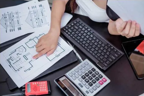 Plans, keyboard and calculator on a project desk
